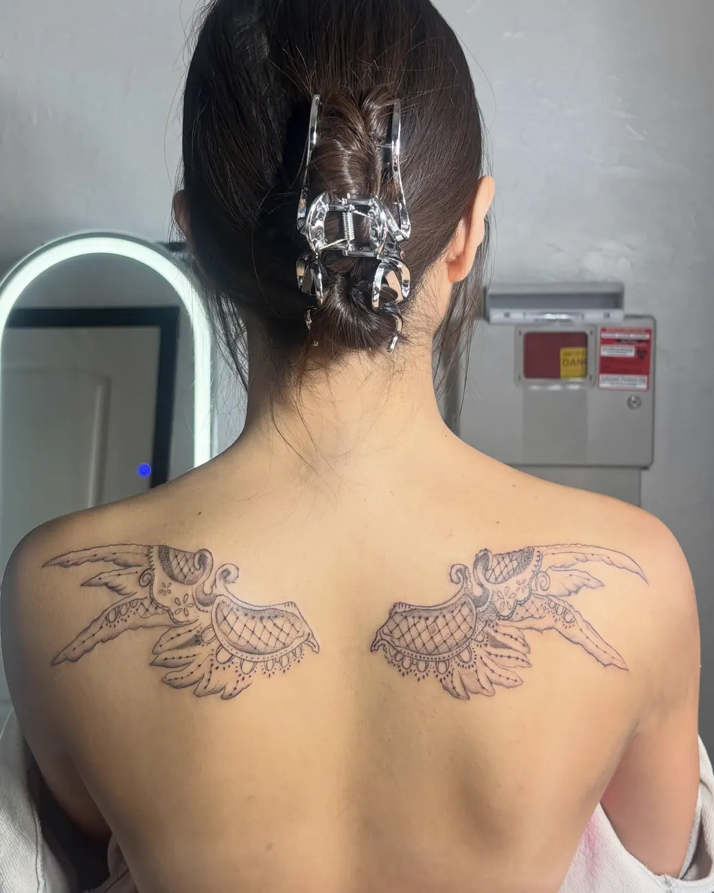 Matching fine line angel wings across the upper back