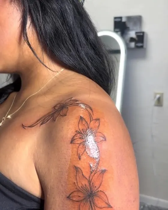 Fine line lilies and flourishes on the shoulder