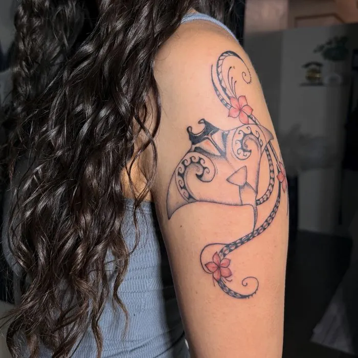 Chamorro tribal shoulder tattoo with red hibiscus accents. View on Instagram.